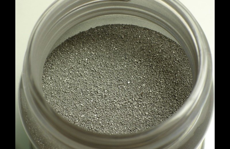 Macro photograph of atomized spherical metal powders in industrial container